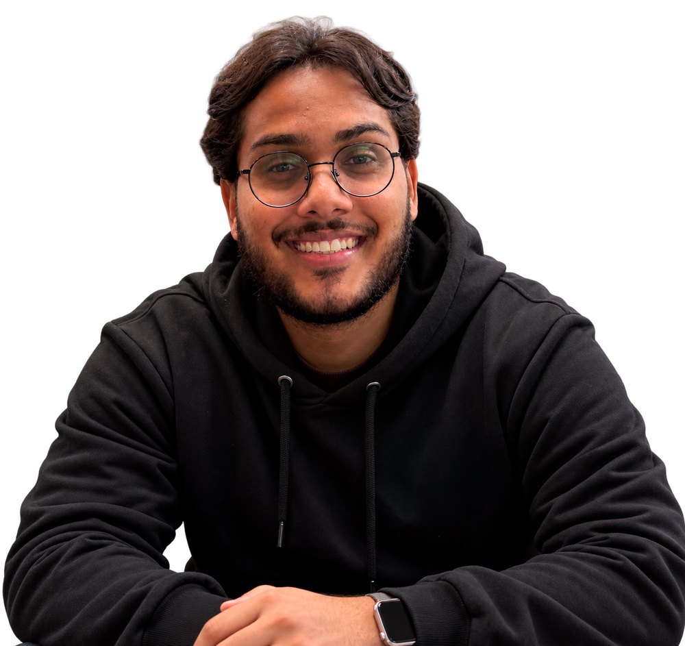 Stephan Teo sorrindo, de óculos e moletom preto, com as mãos sobre a mesa